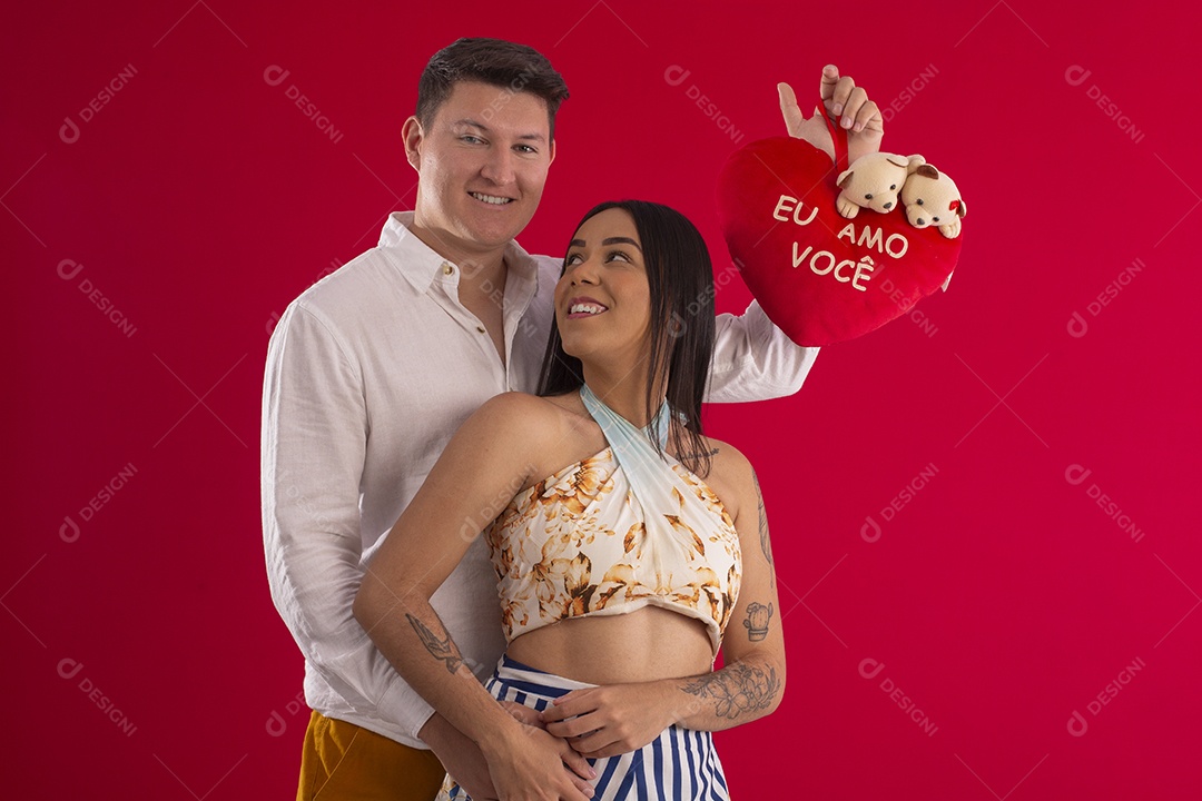 Happy couple smiling holding a plush heart