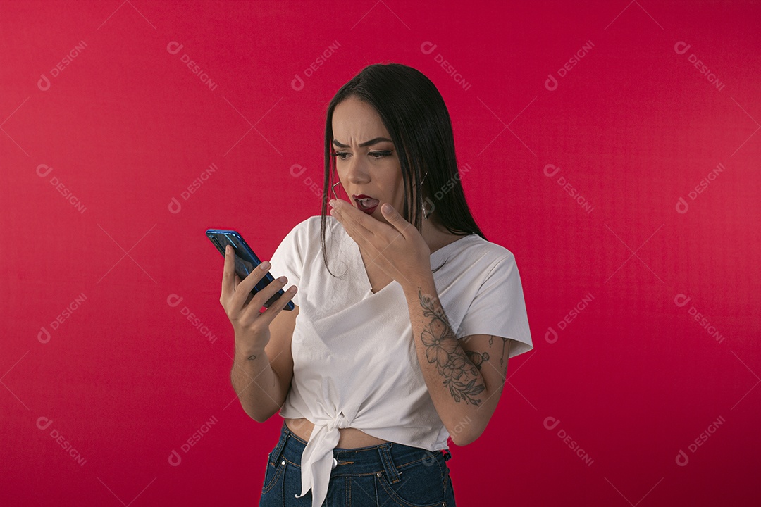 Jovem bonita surpresa com alguma noticia no celular