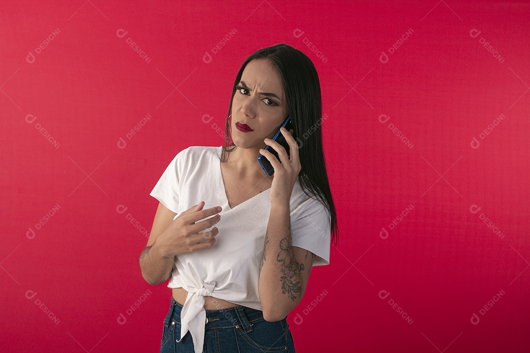 Jovem linda falando no celular com feição de brava