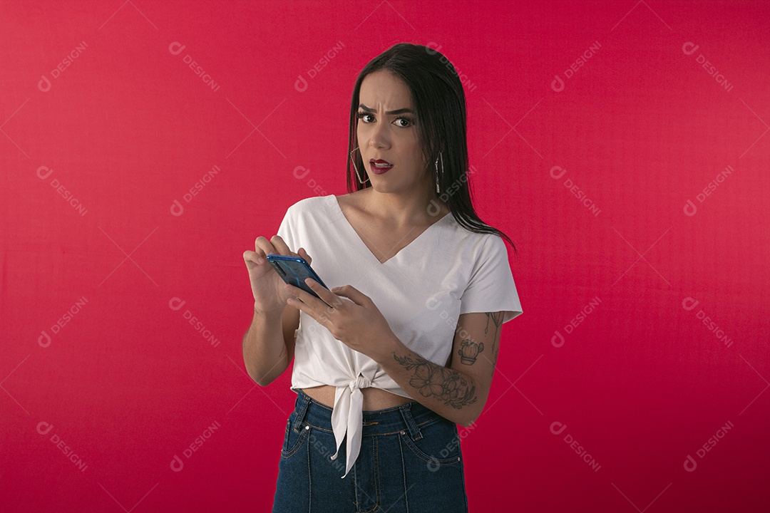 Jovem olhando indignada com celular na mão