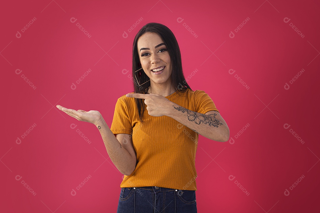 Linda jovem de blusa laranjada apontando apara o lado