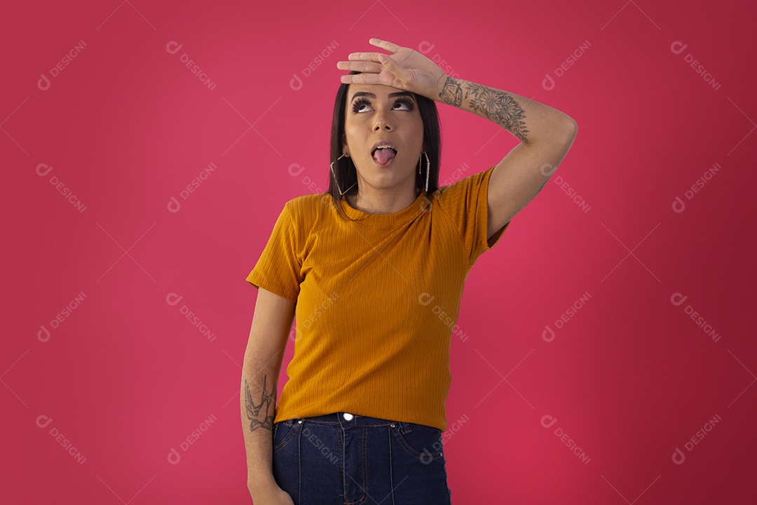 Jovem com mãos no rosto e língua para foto