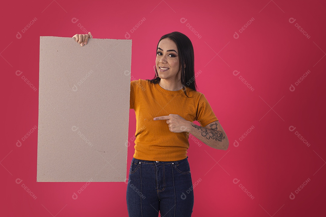 Jovem bonita segurando e apontando para placa em branco