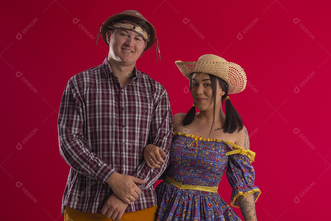 Casal de braços dados e trajados para festa junina