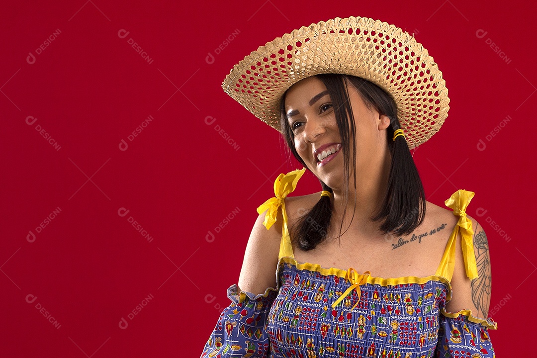 Jovem com trajes juninos e chapéu de palha