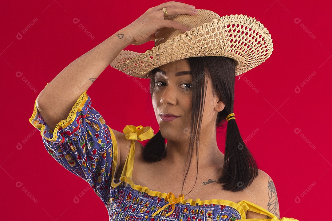 Jovem colocando chapéu na cabeça e trajes juninos