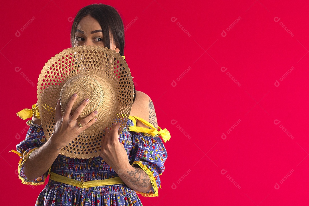 Jovem com chapéu e trajes juninos com gesto de surpresa