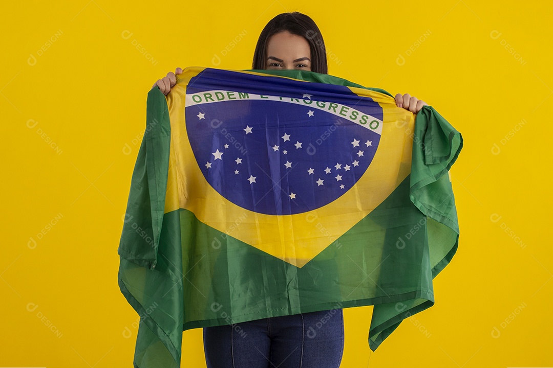 Jovem mulher segurando bandeira do Brasil