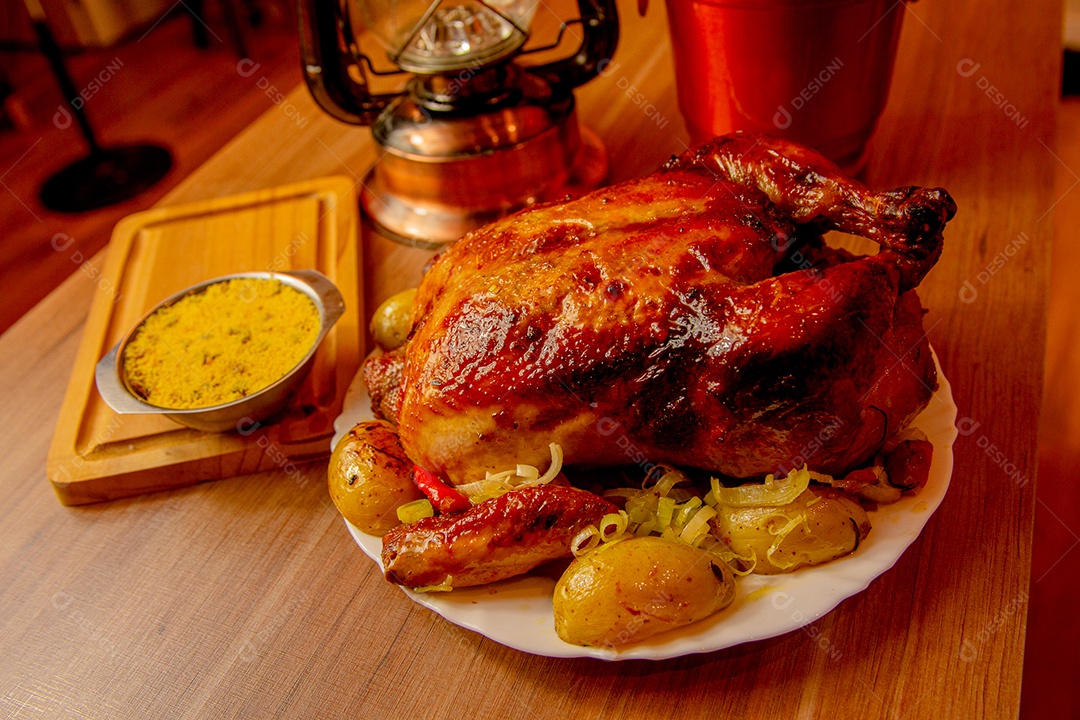 Frango assado com batata e farofa sobre a mesa