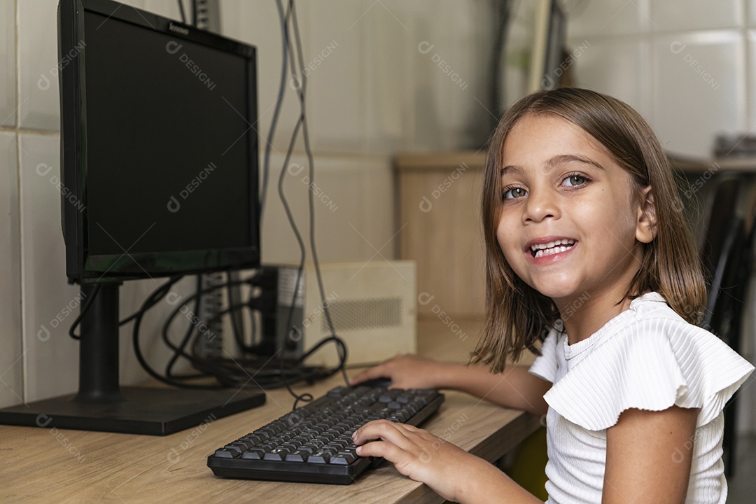 Linda garotinha acessando ao computador