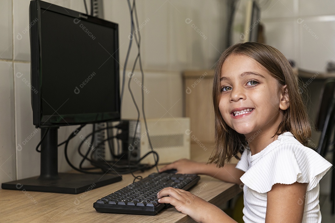 Linda garotinha ligando computador