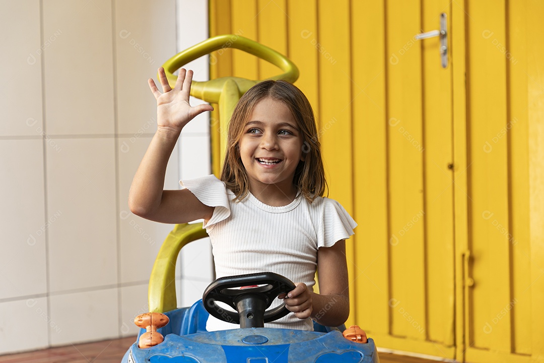 Uma garotinha linda brincando de carrinho de brinquedo