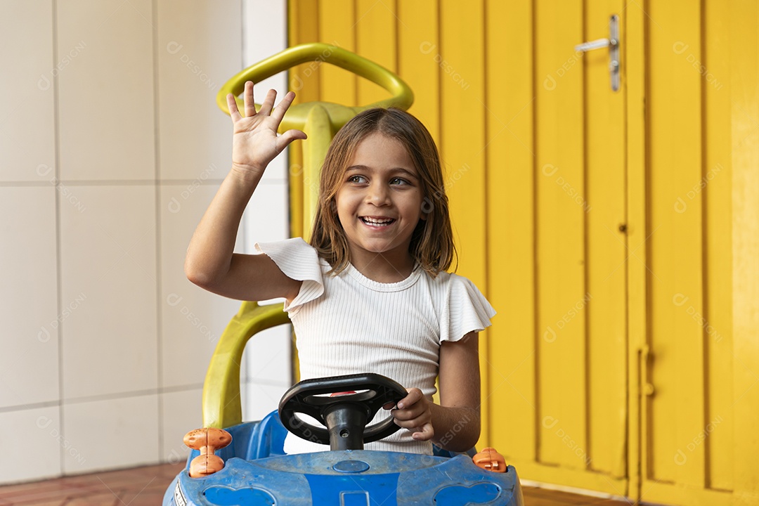 Uma linda garotinha se divertindo em um  carrinho de brinquedo