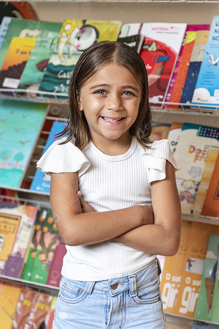 Cute girl with arms crossed in a bookstore