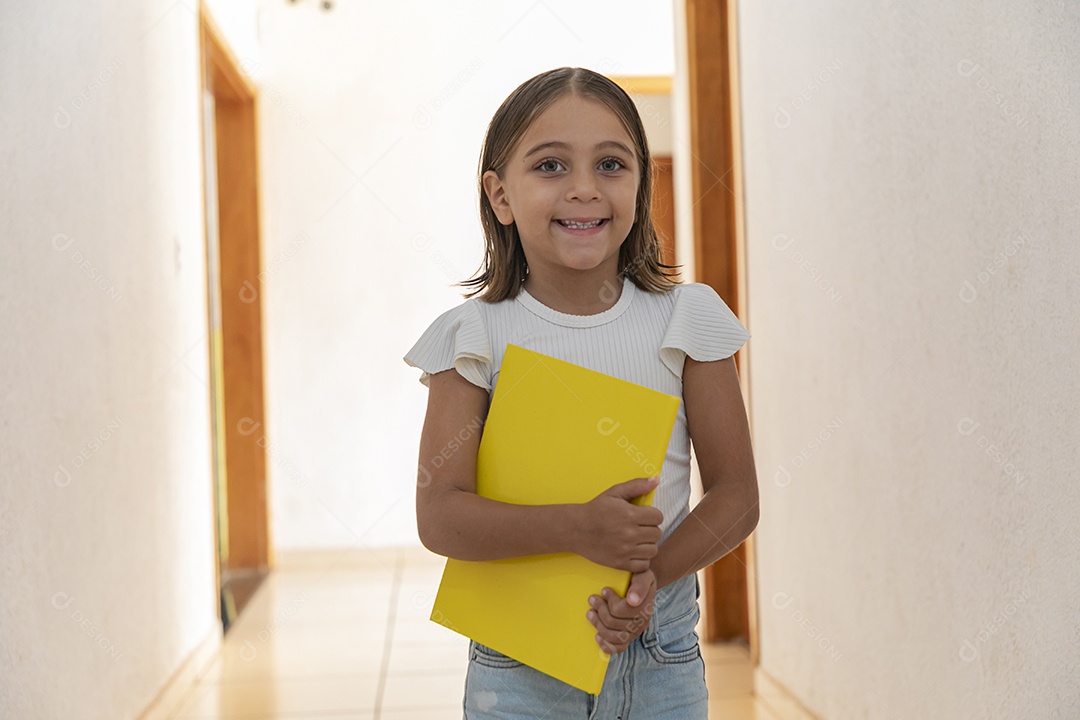 Menina linda segurando caderno amarelo