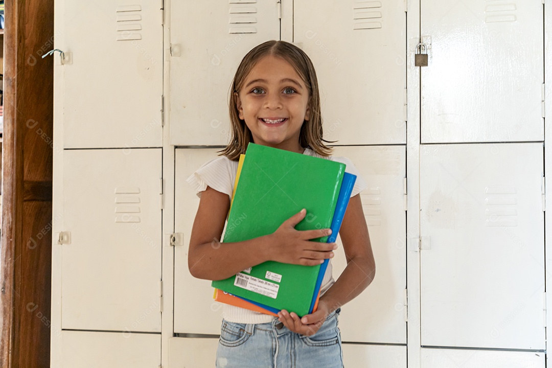 Linda garotinha com muitos cadernos nas mãos