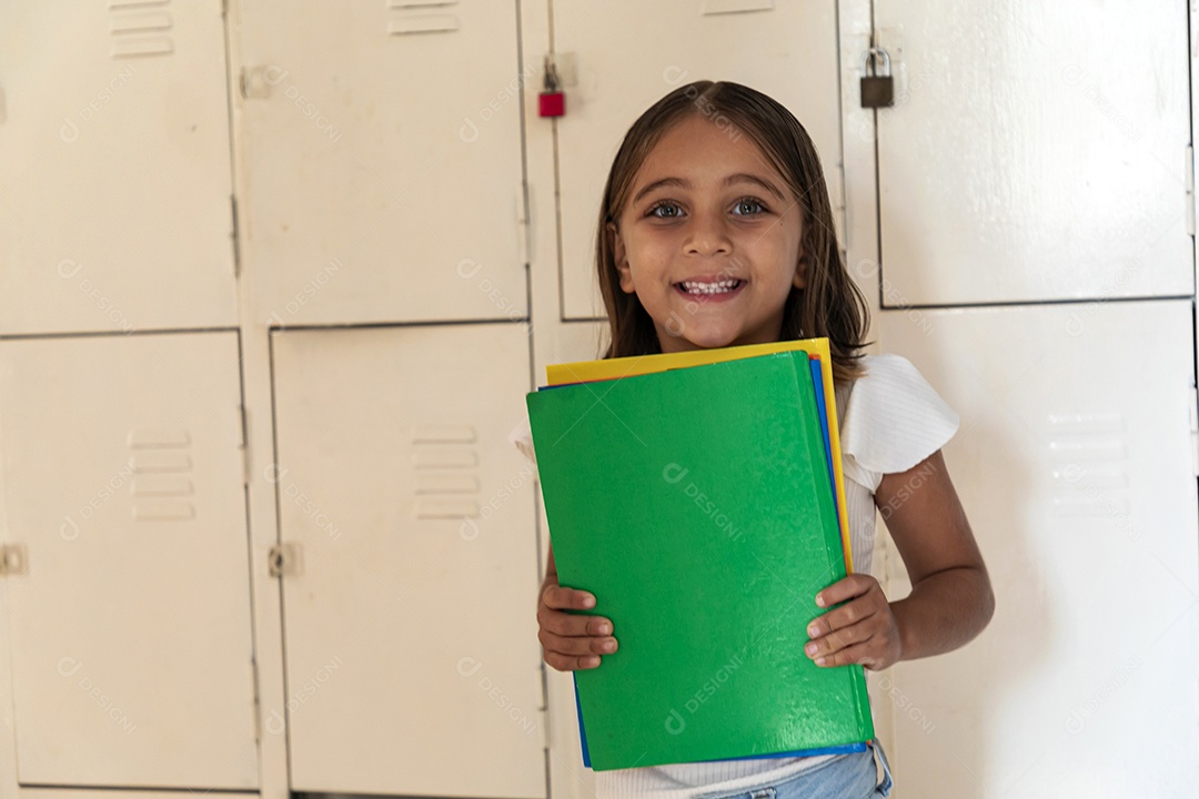 Menininha feliz com muitos livros na mãos