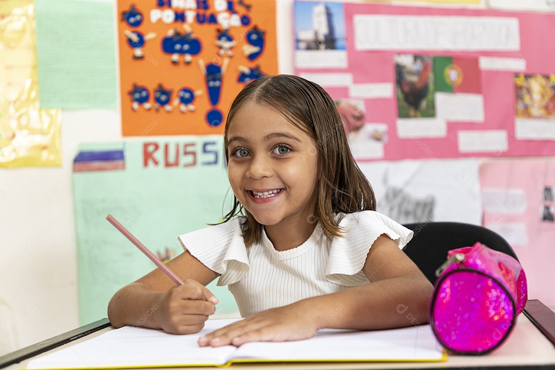 Menina linda escrevendo na sala de aula
