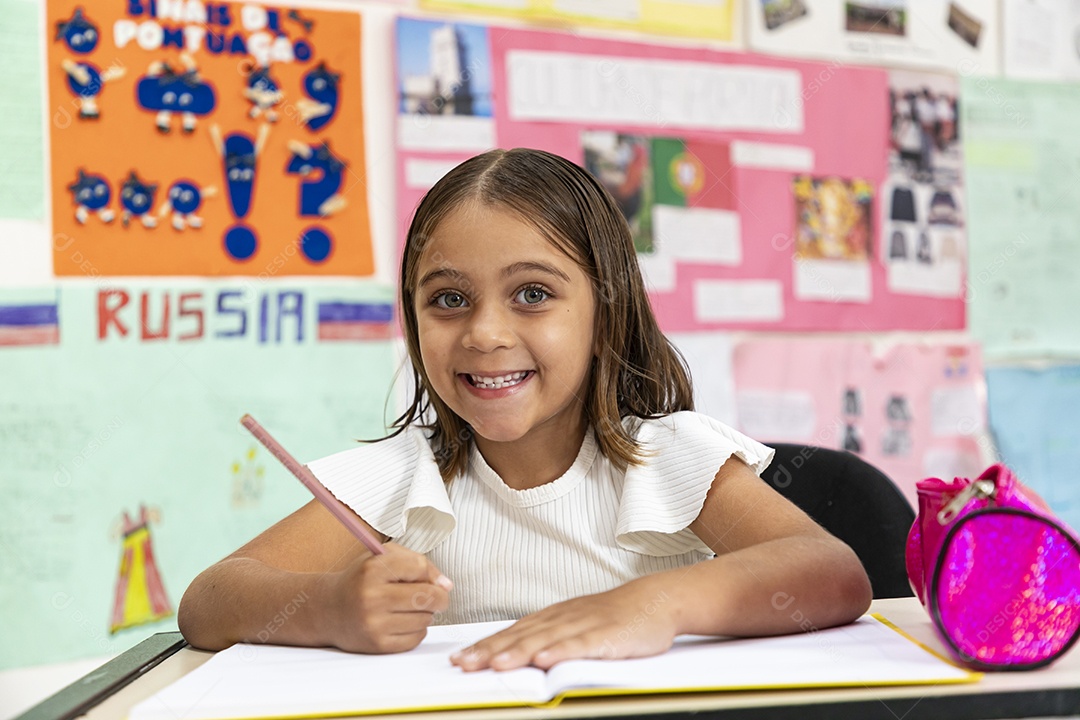 Menina escrevendo no caderno na sala de aula
