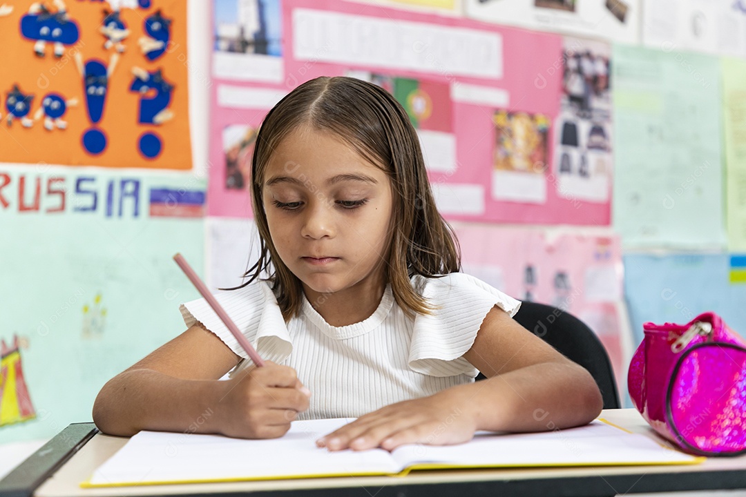 Linda menina escrevendo na sala de aula