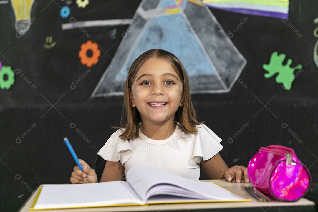 Linda garotinha assinando em seu caderno