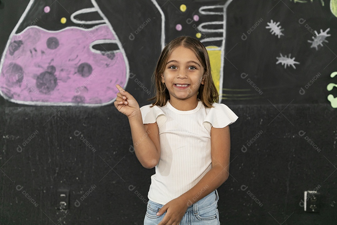 Linda menina sorrindo apontando para o lado