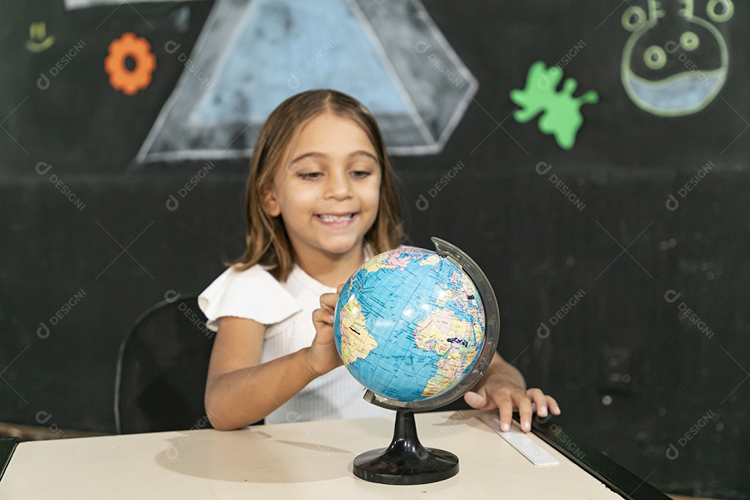 Menininha rodando um globo terrestre