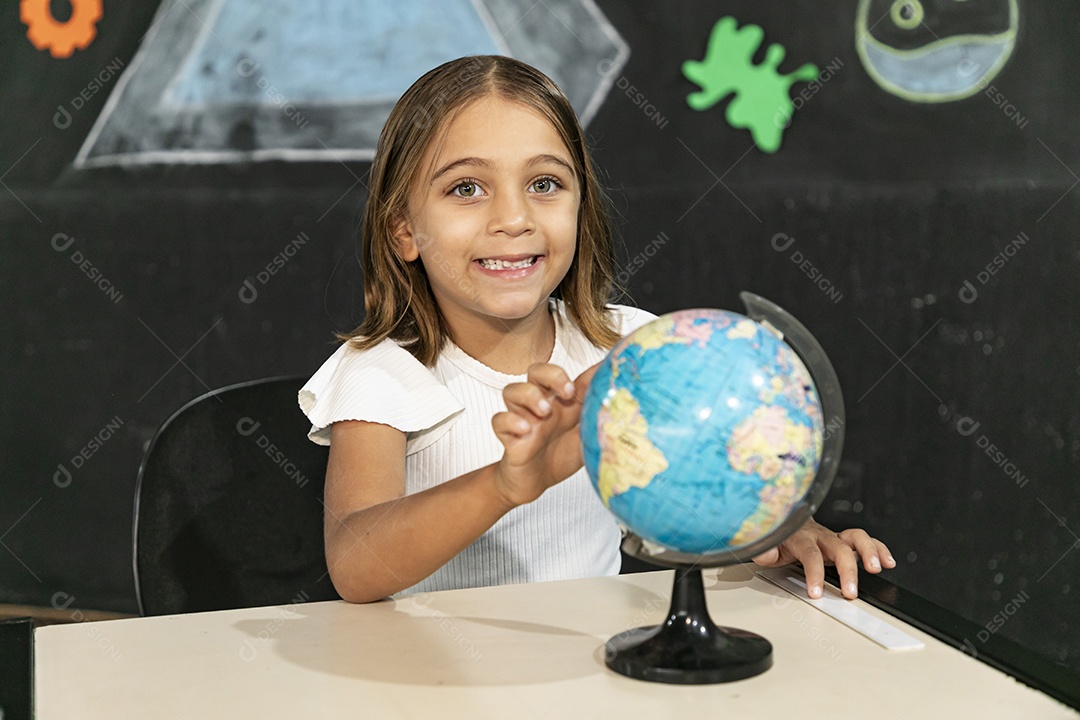 Linda criança olhando um globo terrestre