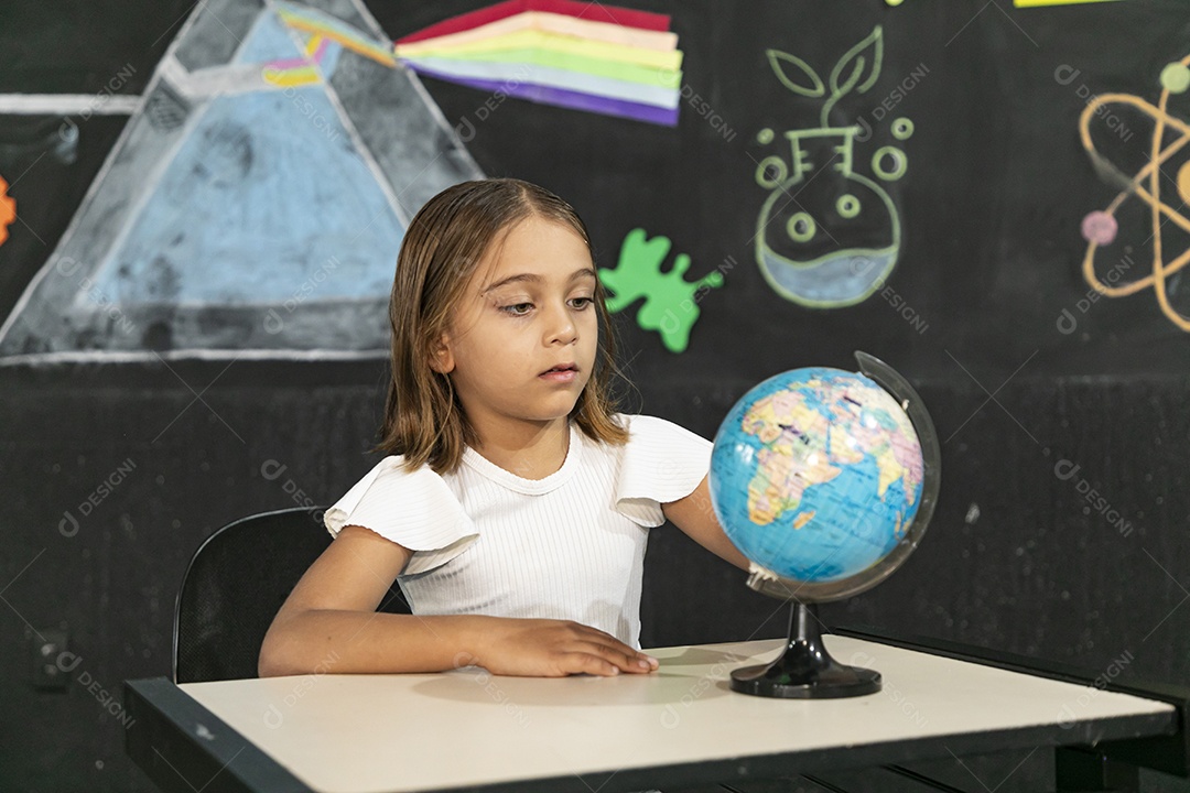 Menina concentrada em um globo terrestre