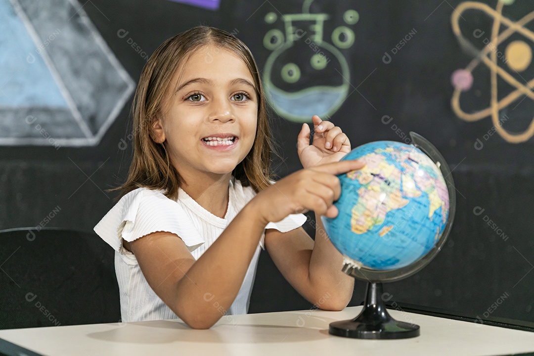 Linda menina apontando para o globo mundial