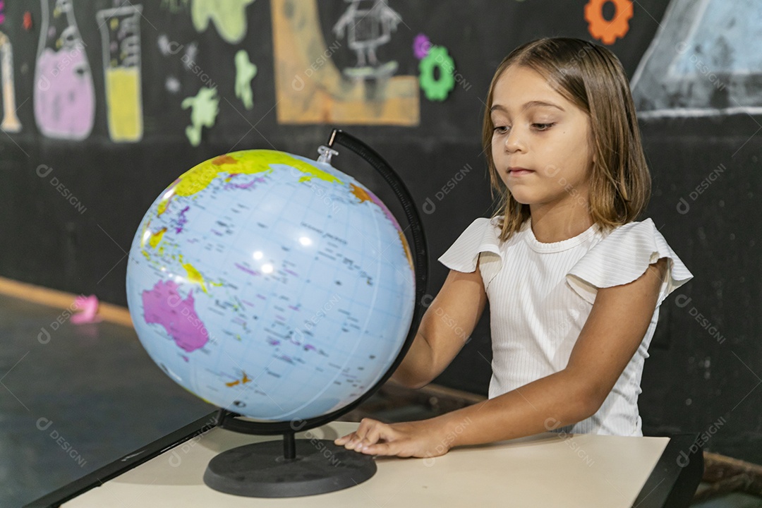 Garotinha olhando para um globo mundial