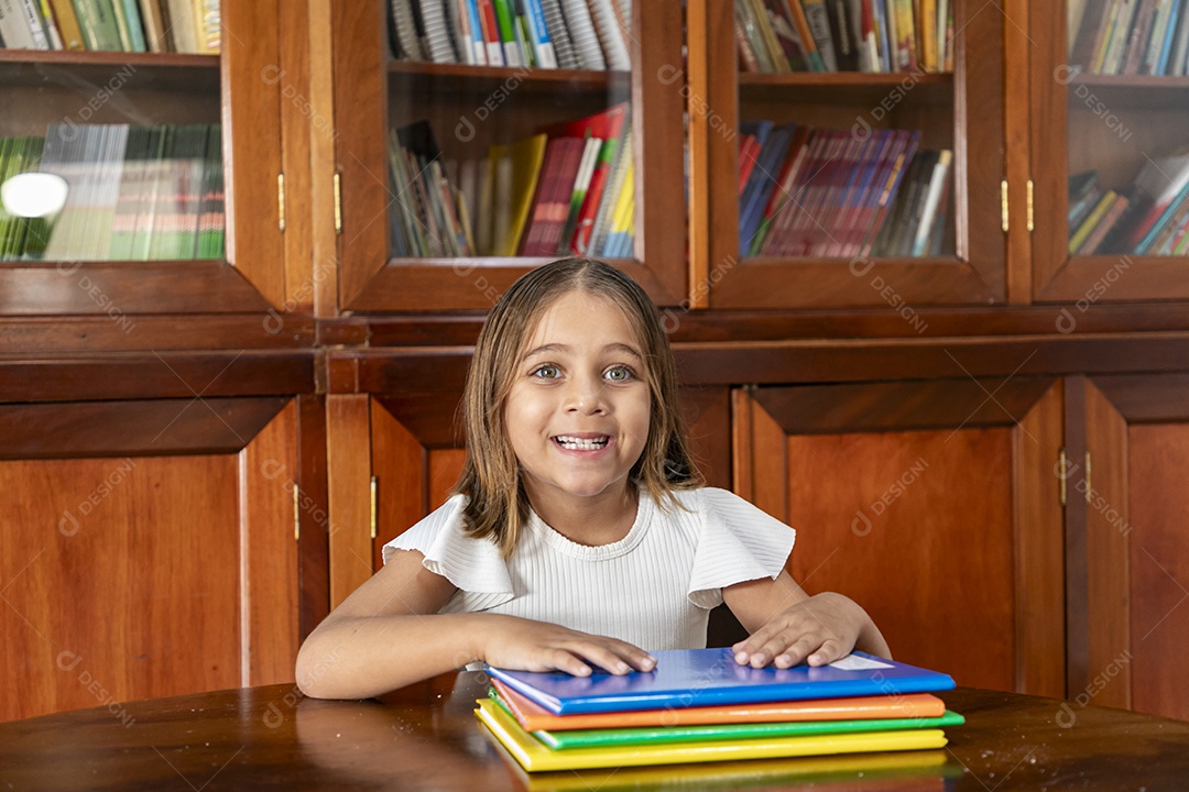 Linda menina com muitos cadernos sobre uma mesa de livraria