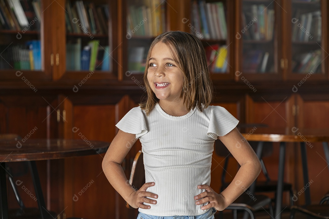 Linda garota com mãos na cintura em uma livraria