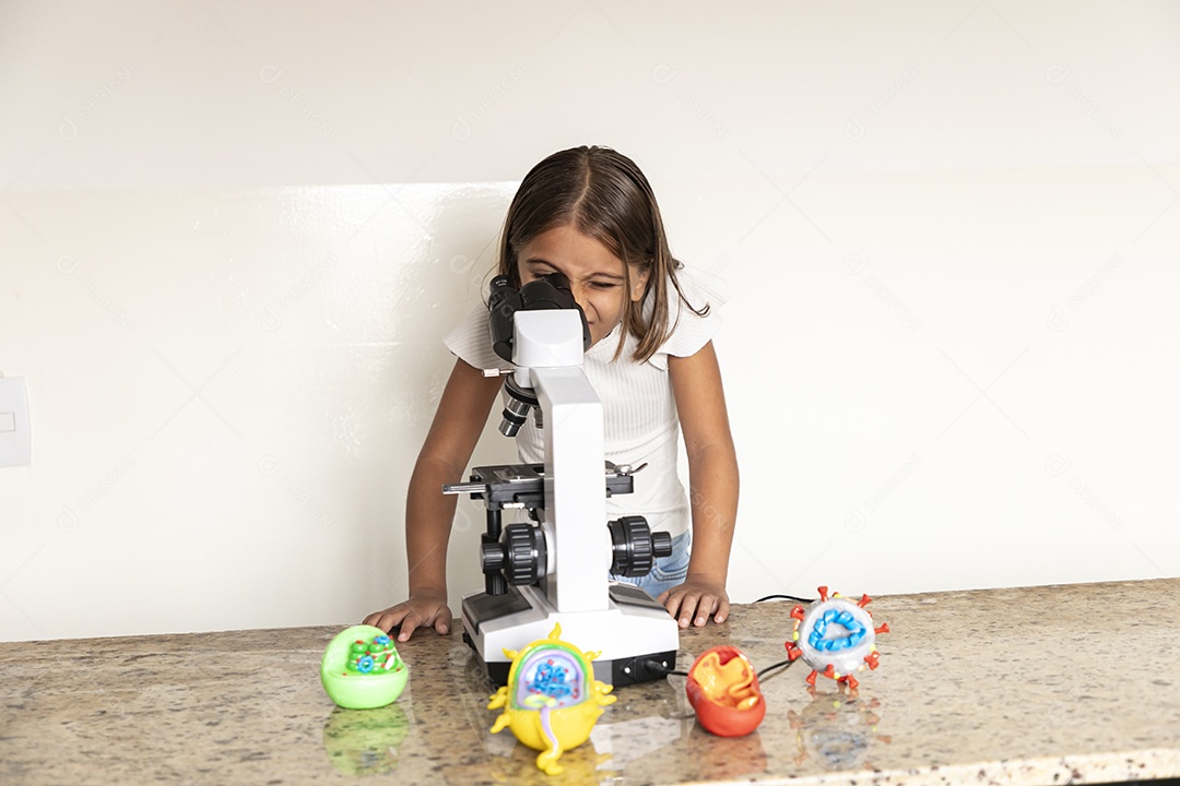 Menina olhando através de um microscópio