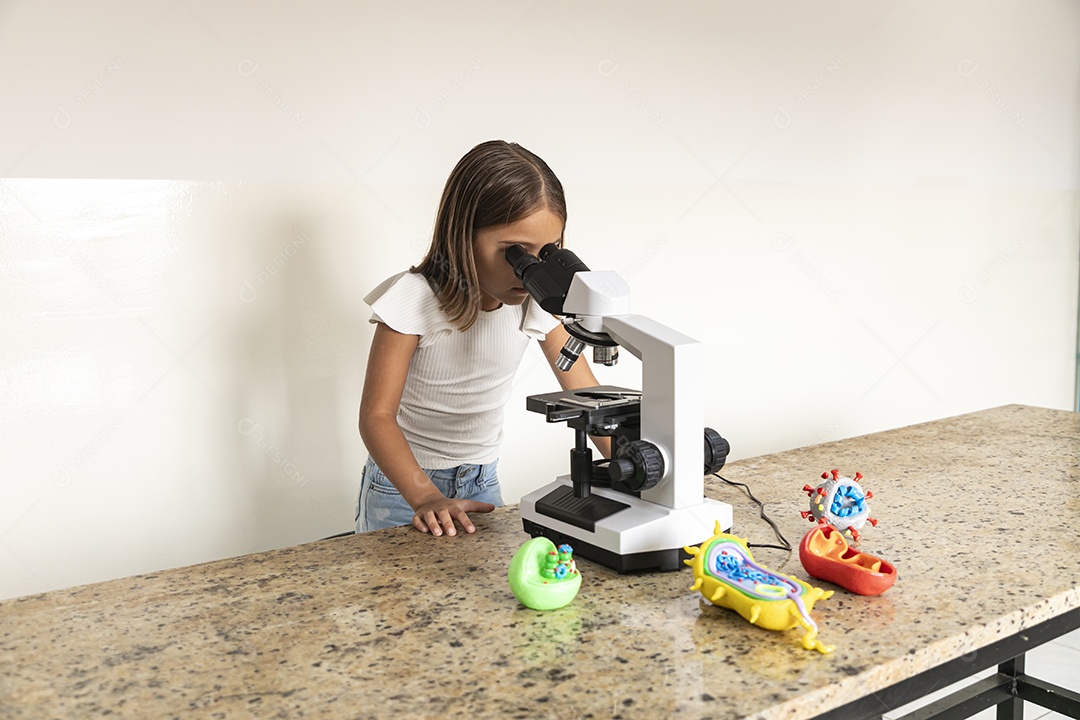 Beautiful girl looking through a microscope