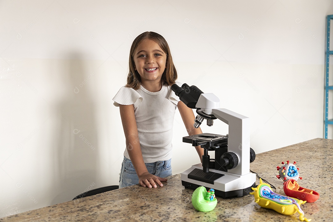 Garotinha contente na frente de um microscópio