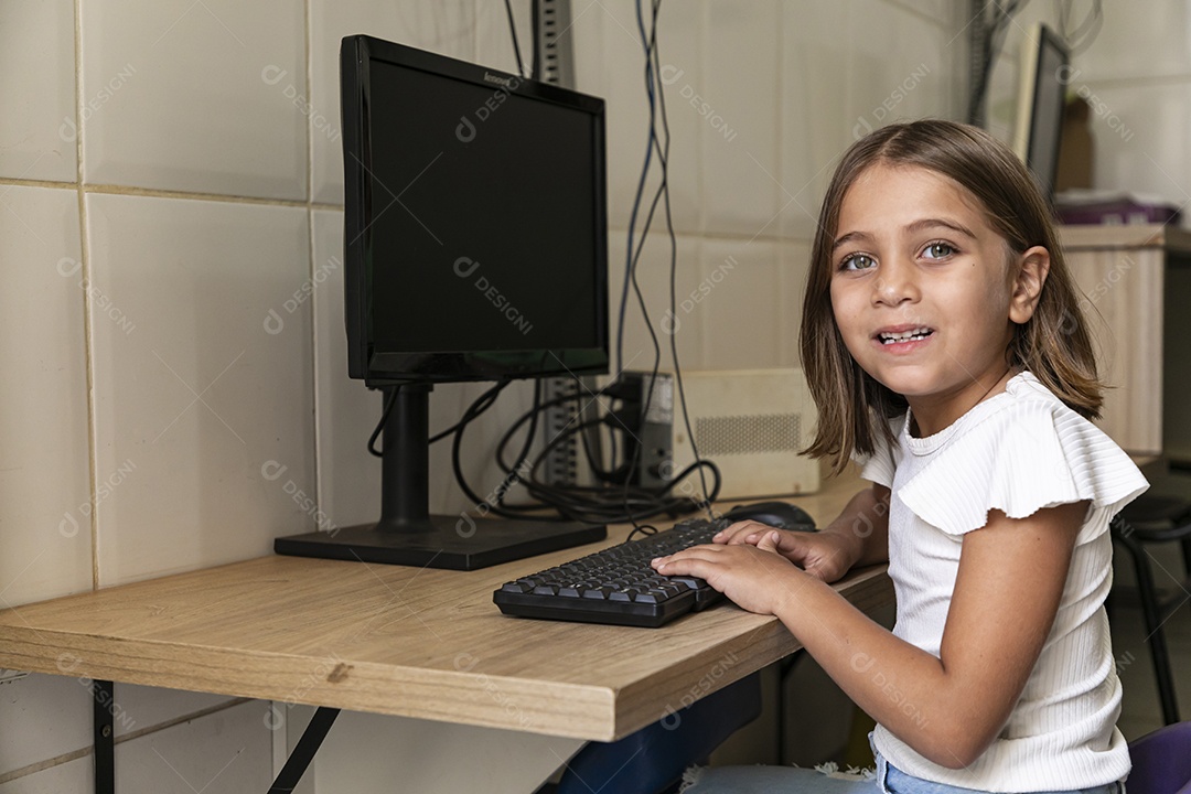 Linda garotinha mexendo em um computador