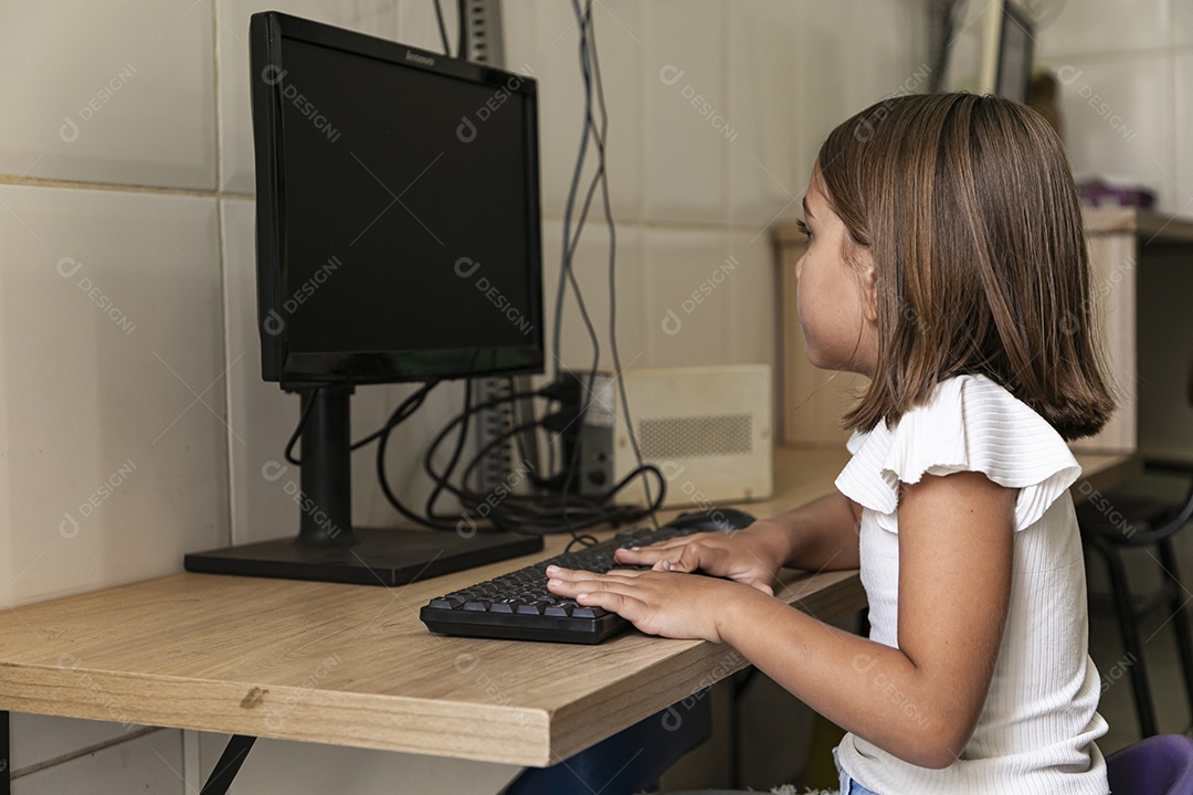 Linda garotinha concentrada no computador