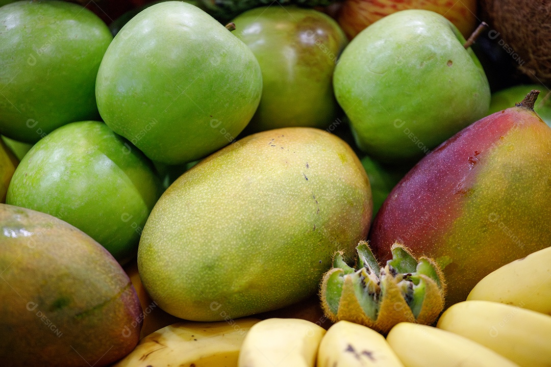 Maças verdes mangas e variadas frutas em uma bancada