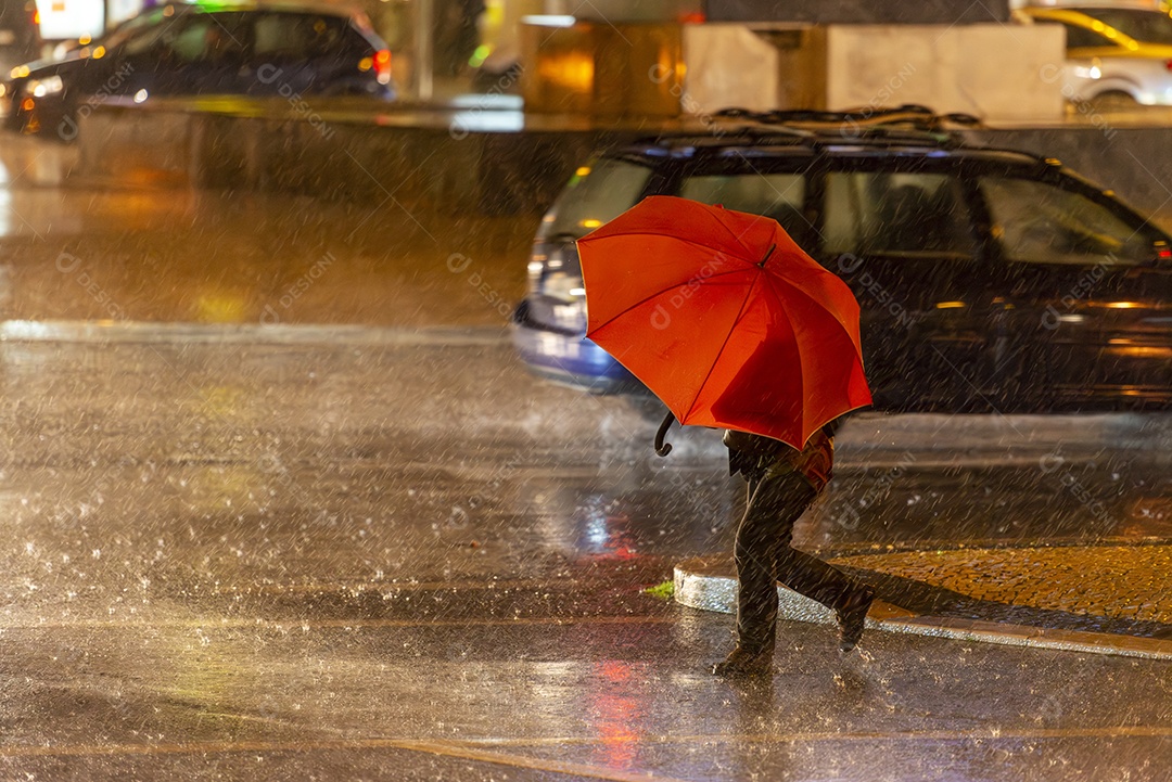 Mulher atravessando a rua segurando um guarda chuva