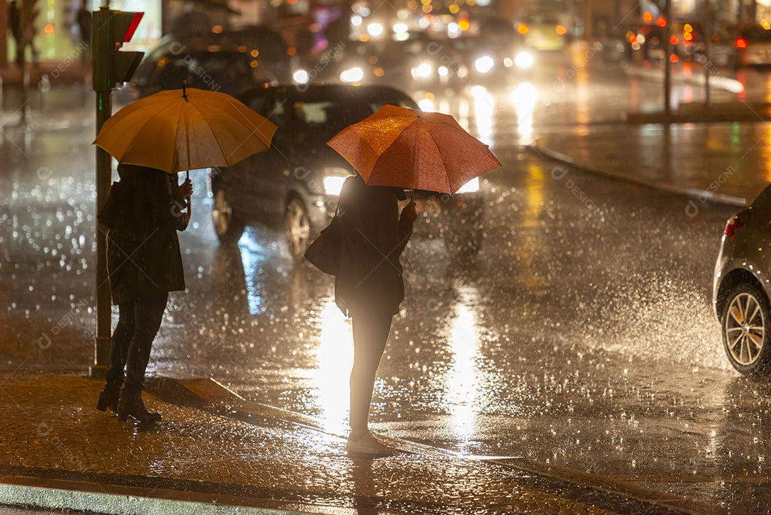 Mulher atravessando a rua segurando um guarda chuva