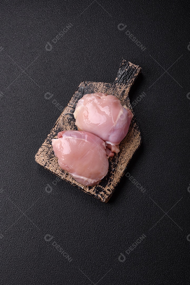 Filé de frangos frescos sobre tábua de madeira