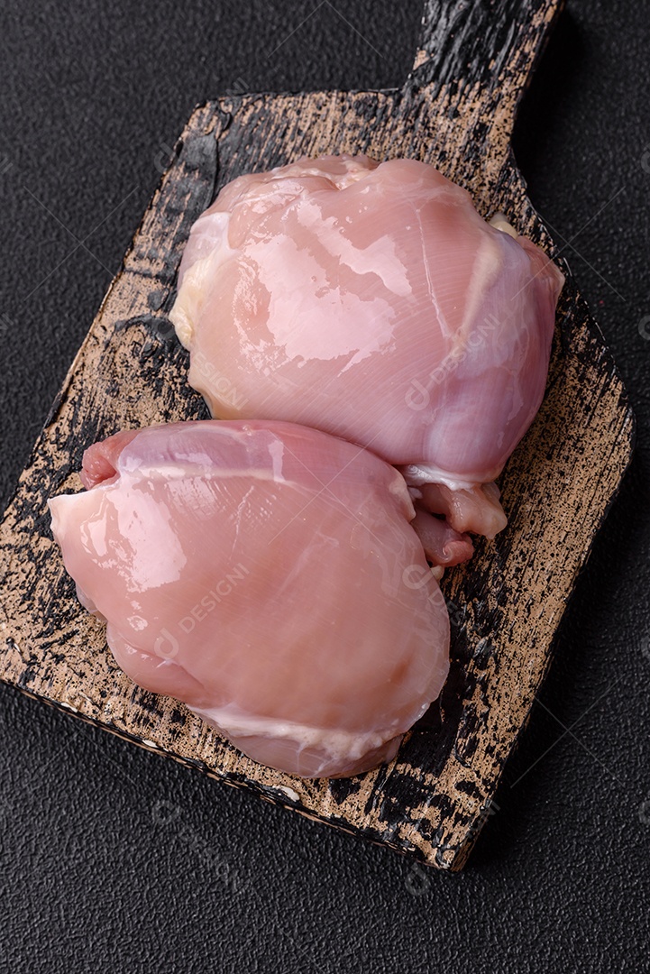 Filé de frangos frescos sobre tábua de madeira
