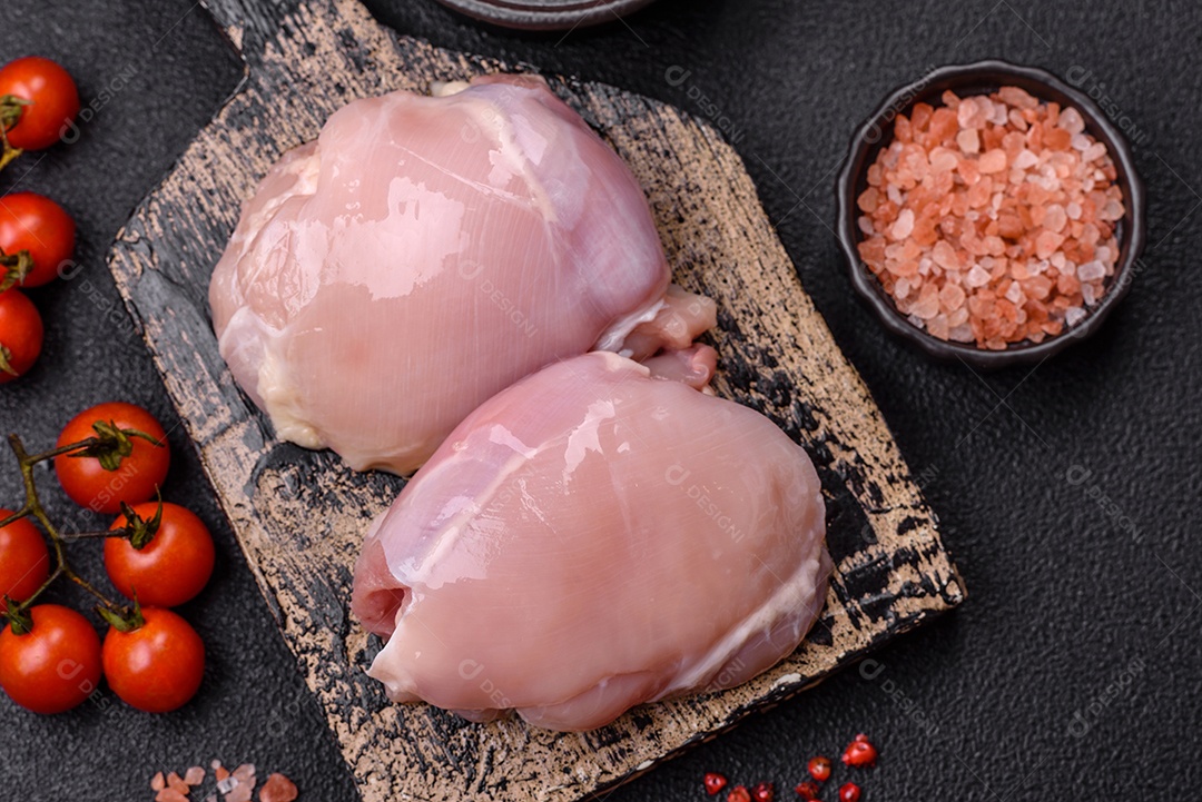 Filé de frangos frescos sobre tábua de madeira