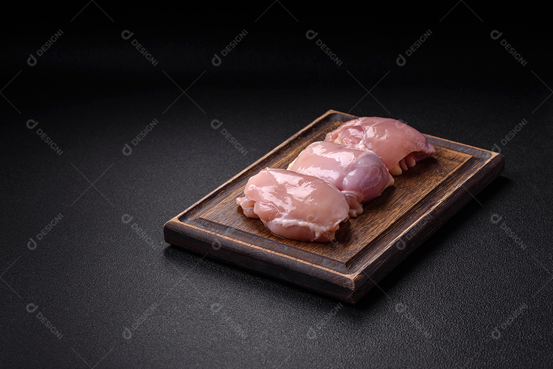Filé de frangos frescos sobre tábua de madeira