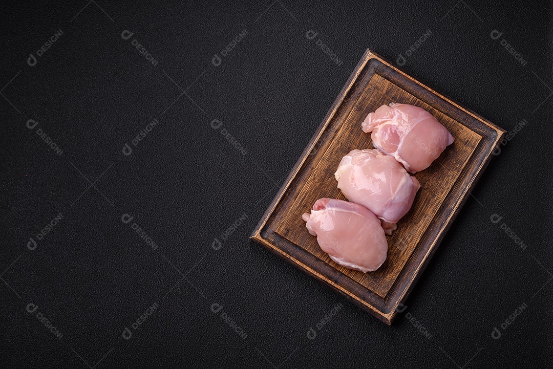 Filé de frangos frescos sobre tábua de madeira