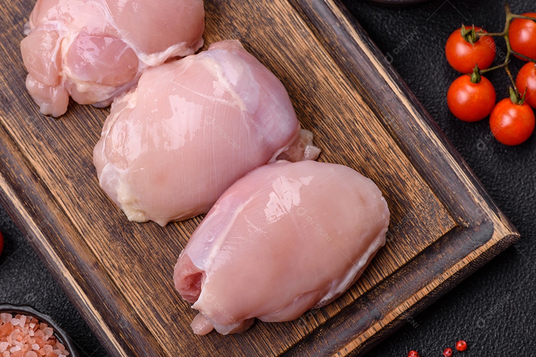 Filé de frangos frescos sobre tábua de madeira