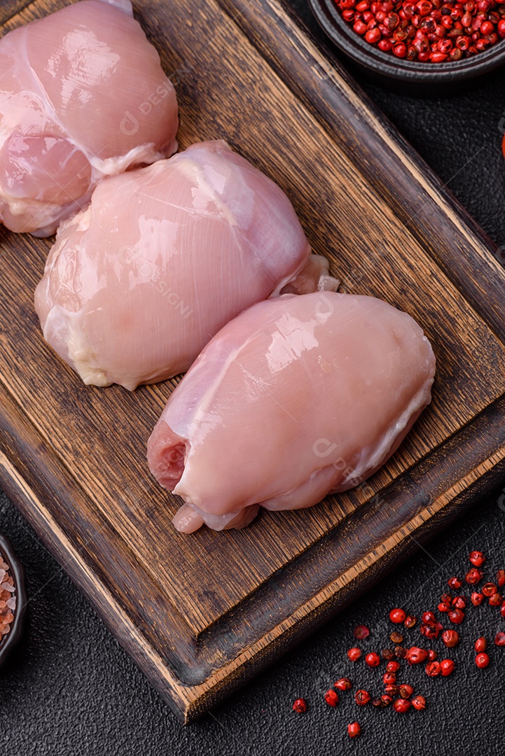 Filé de frangos frescos sobre tábua de madeira