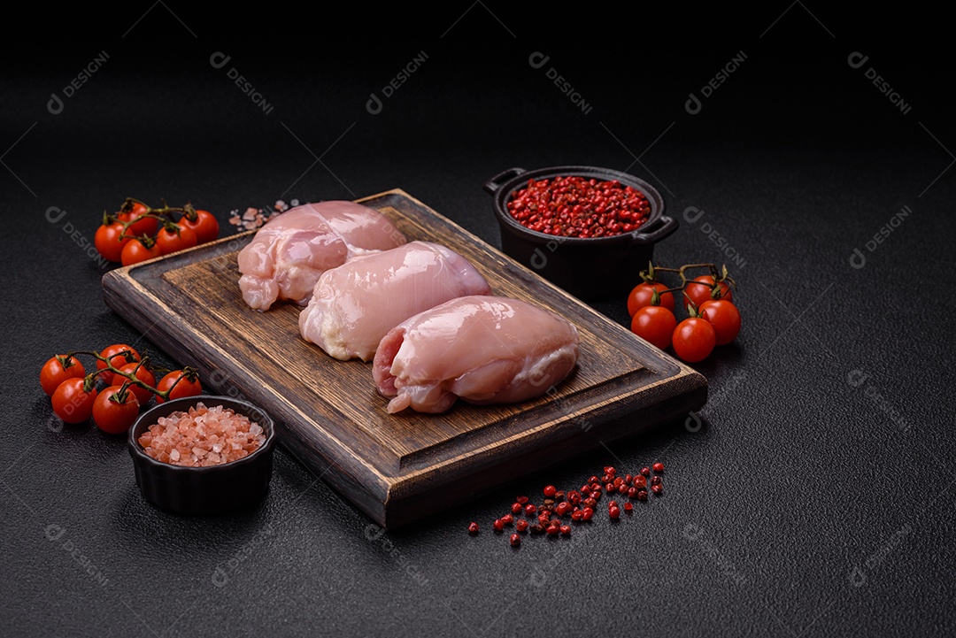 Filé de frangos frescos sobre tábua de madeira