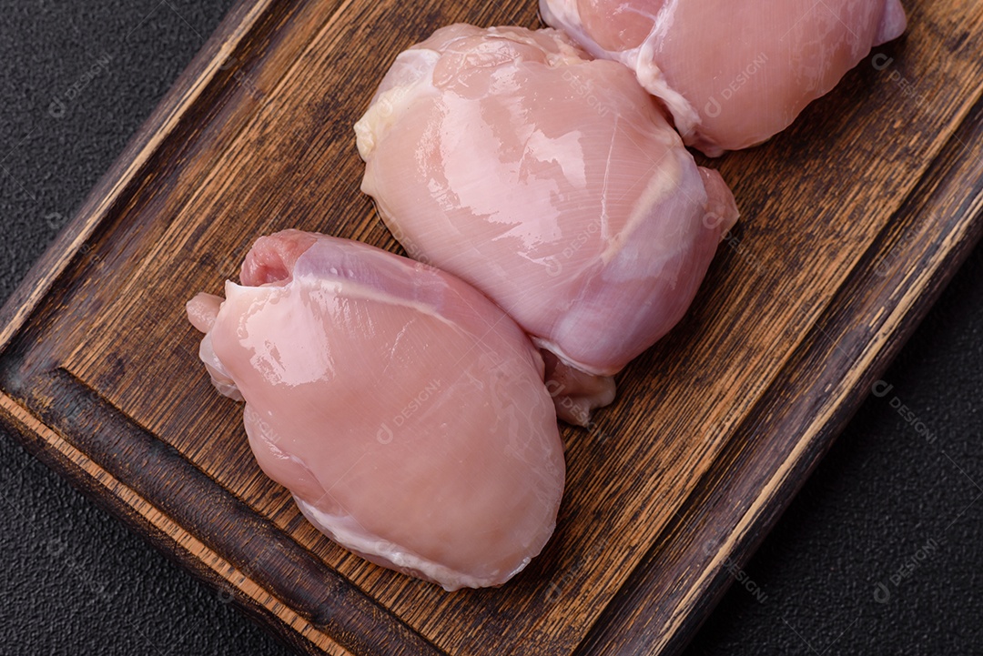 Filé de frangos frescos sobre tábua de madeira